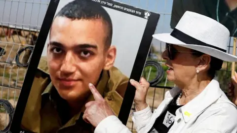 Edan Alexander's grandmother points to his picture (20/04/25)