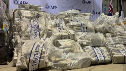 A pile of large plastic bags containing dozens of packages and bearing the label of Australian Federal Police