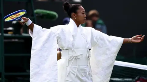 Naomi Osaka wears an all-white kimono as she prepares to warm-up before her first-round match at Wimbledon