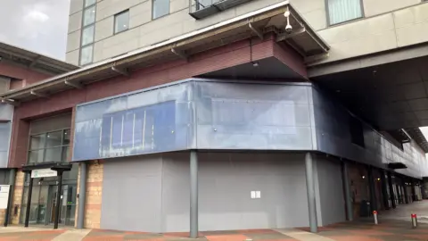 An empty unit in a leisure park - a building with metal frontage