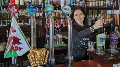 The Lamb Vladyslava Krapyvka behind the bar of The Lamb pub 
