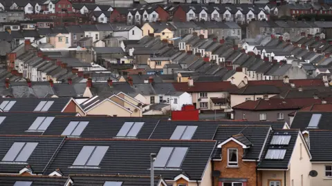 A view of the roofs and houses from a high vantage point. Most are terraced houses. 