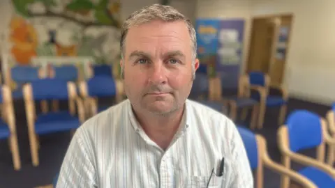 Dr Dan Goodare sits in a GP waiting room