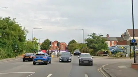 Google A road junction with six cars visible and a number of houses in the background
