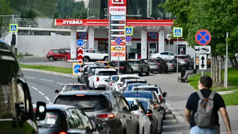 Queue of cars leading to a fuel station.