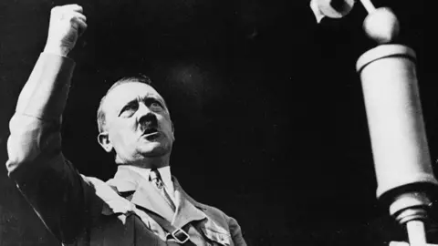 Hulton-Deutsch Collection/CORBIS/Corbis via Getty Images Adolf Hitler raising his fist at the Berlin International Auto Show