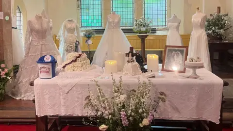 Dresses on mannequins behind a church altar