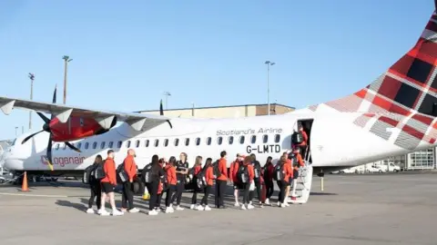 ISLE OF MAN AIRPORT Members of the Isle of Man team wearing red jackets boarding a Loganair plane at Ronaldsway Airport.