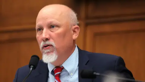 Chip Roy wearing a blue suit and red tie