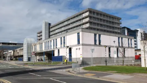 The Aberdeen Royal Infirmary building which is a functional hospital building next to a road