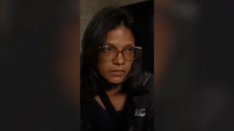 Close-up of woman wearing black jacket and glasses