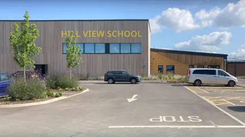 Hill View School and car park. The school is a rectangular building with the school's name in yellow letters.