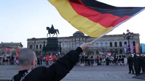 Getty Images Un partidario del grupo de extrema derecha AFD se burla de los manifestantes antifascistas.