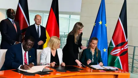 Kenya Foreign Affairs Ministry/X  Germany Chancellor Olaf Scholz and Kenya's President William Ruto lead the signing of the deal in Berlin