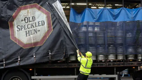 Getty Images An employee closes the curtain on the side of a delivery truck branded with the logo for "Old Speckled Hen" ale, produced by Greene King PLC, on a truck loaded with beer kegs at the company's brewery in Bury St Edmunds.