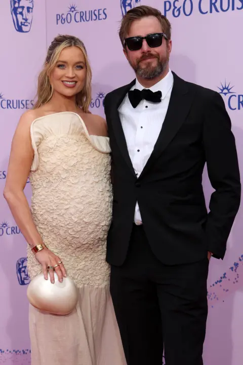 Getty Images Laura Whitmore in a cream dress with her bump showing with Iain Stirling in a dinner jacket
