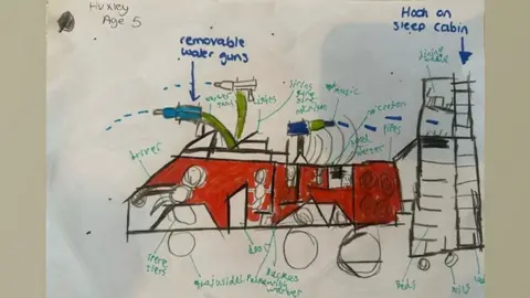 Cambridgeshire Fire and Rescue A drawing by Huxley aged five showing a futuristic fire engine, with a red body.  Around the drawing is writing pointing to the removable water guns, the lights, sirens and music.