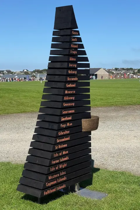 A fountain with all 24 competing islands engraved, where representatives from each island pour water from their respective islands into a fountain