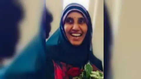 Family handout A grainy photograph of Mumtaz Member, a 56-year-old, slim, South-Asian woman smiling and wearing a turquoise headscarf.