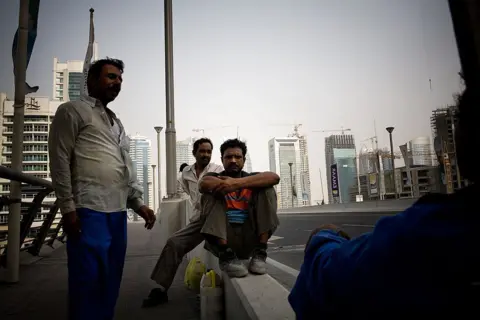 Getty Images Migrant workers stand near some of the many skyscrapers being built during a construction boom July 10, 2008 in Dubai, United Arab Emirates. 