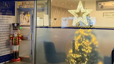 A nutcracker statue stands on the porch of a funeral home. 