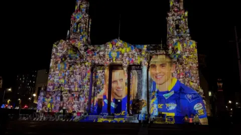 A light projection showing Rob Burrow and Kevin Sinfield