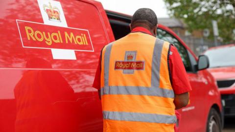 Royal Mail worker in front of a van