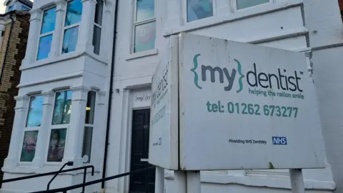 The Mydentist practice in Bridlington is a large, three-floor Victorian building, painted white, with an accessible ramp leading to a black front door.