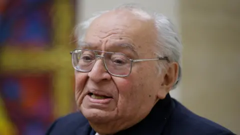 Peruvian theologian and Dominican priest Gustavo Gutierrez, wearing a cassock and glasses, speaks during a news conference in 2014. 