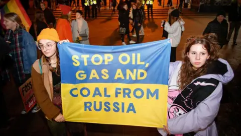 Getty Images Manifestantes na Polônia exigem o fim de todas as importações de combustíveis fósseis da Rússia, 2022