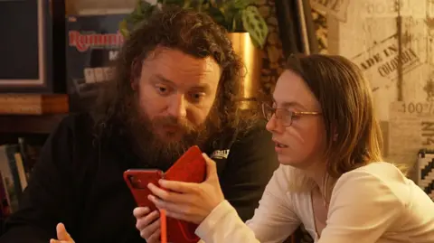 A man and woman with autism chat in a cafe.