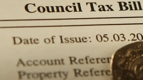 A close up of a council tax bill, with the date of issue partly cut off and account reference obscured by a 20p coin.