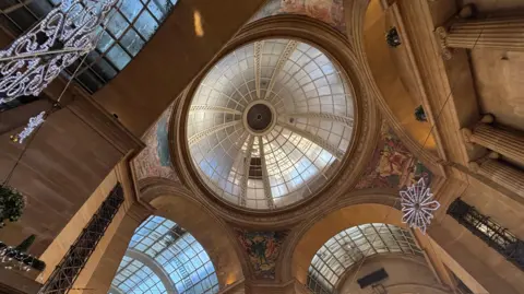 A shot looking directly up inside the council house at the vaulted ceiling and glass dome.