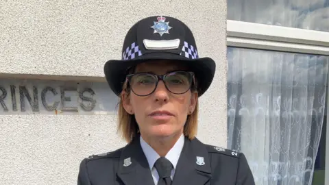 Supt Becky Webster wears a police hat and uniform