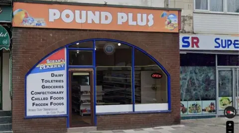 LDRS The front of 52 Coronation Street Blackpool which has a Pound Plus sign and Soran's Market sign with a blue surrounding  on a bricked building