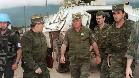 AFP via Getty Images Ratko Mladic is photographed in military uniform surrounded by his fellow officers during the war in the Balkans