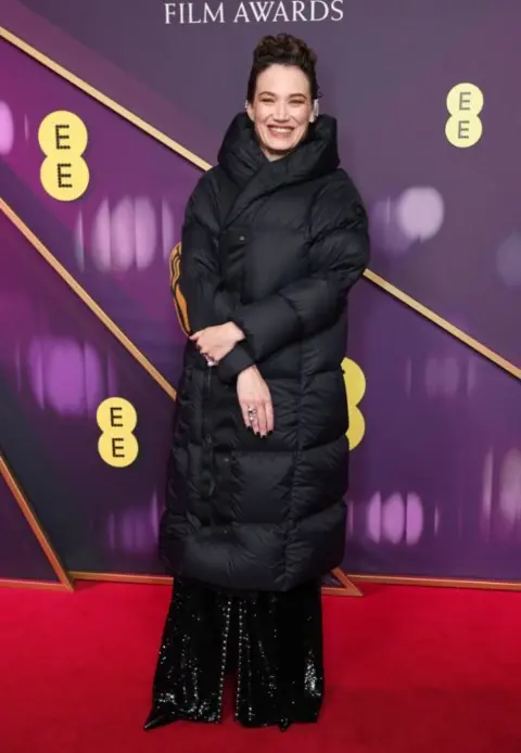 Getty Images Coralie Fargeat in a black puffa coat over her long, black outfit