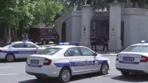 Reuters Police cars and officers are positioned around the front gate of the Israeli embassy in Belgrade.