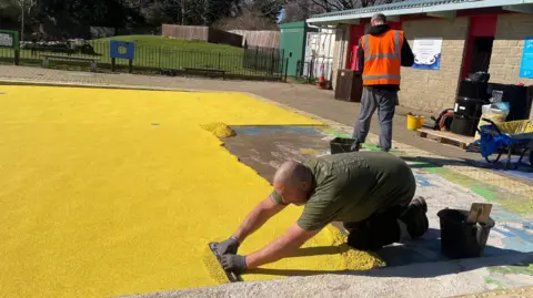 Swindon Borough Council A worker smooths the new surface of the water park.