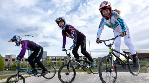 Better.org.uk The kids are positioned to ride down a slope on their bikes. 