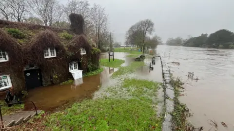 River appears close to bursting its bank near tea rooms at Llanrwst, Conwy