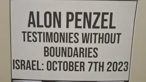 Alon Penzel A close-up of a placard with the words "Alon Penzel, testimonies without boundaries. Israel: October 7th 2023"