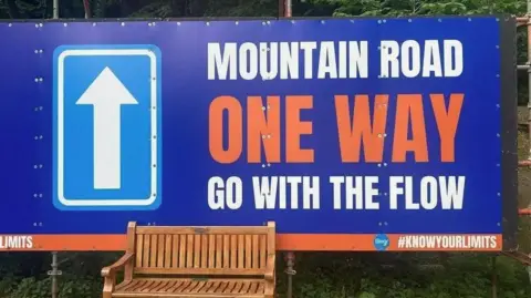 IOM CONSTABULARY A large blue sign with Mountain Road One Way go with the flow written on it.