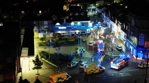 Eddie Mitchell Ambulances, police cars and fire engines, with a cordon around a street, pictured from above at the scene of a fire in Bognor Regis.