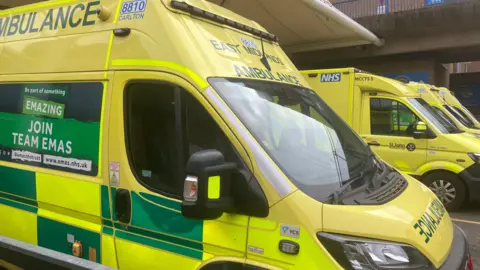 Several East Midlands Ambulance Service ambulances waiting at an accident and emergency department at a hospital in the East Midlands.