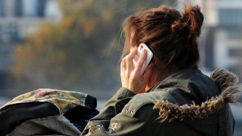 Generic picture of a woman from the back making a mobile phone call