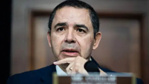 CQ-Roll Call, Inc via Getty Images A close-up of Henry Cuellar speaking into a microphone and holding his hand to his chin