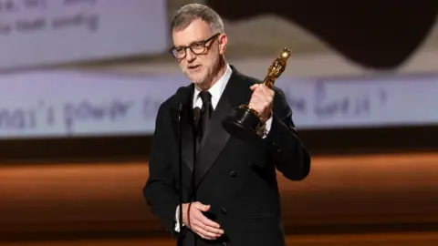 Getty Images Paul Thomas Anderson on stage at the Academy Awards accepting an Oscar
