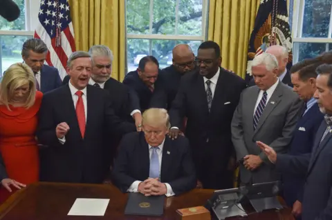 Getty Images Trump praying in 2017