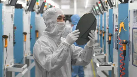 Getty Images Employees work on the production line of silicon wafer at a factory of GalaxyCore Inc. on May 25, 2021 in Zhejiang, China.